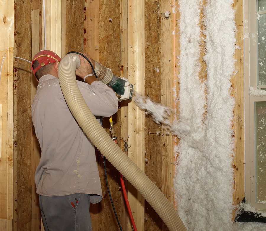 worker applying insulation in the walls